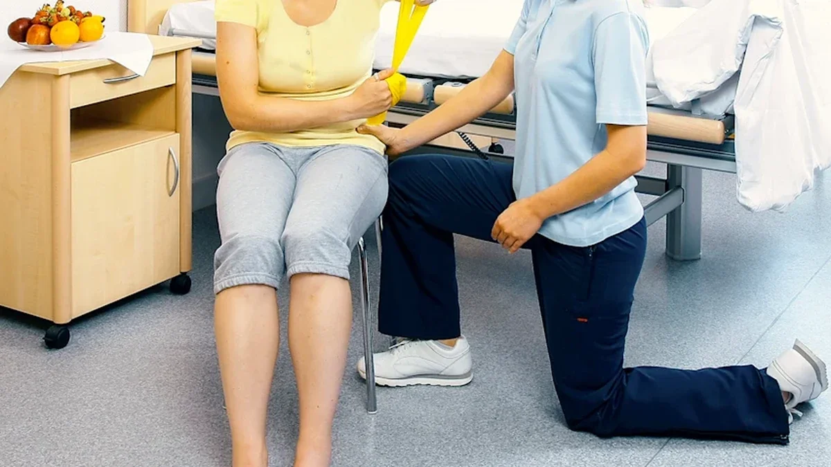 Hedefli kas reinnervasyonu (TMR): Oturan kullanıcının terapist eşliğinde direnç bandıyla kol çalışması
